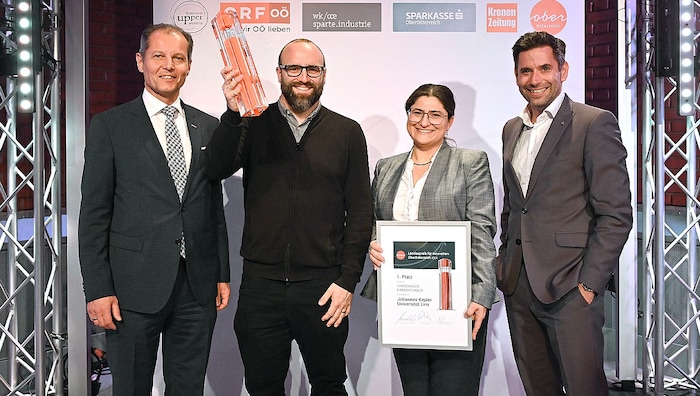 Martin Bergsmann von der Sparte Industrie der Wirtschaftskammer OÖ (li.) und Manuel Molnar (re.), Vorstand der Sparkasse OÖ, gratulierten Ian Teasdale und Eleni Priglinger vom Institut für Chemie der Polymere an der JKU zur Entwicklung von druckbarem Material zur Herstellung von synthetischen Knochen. 
