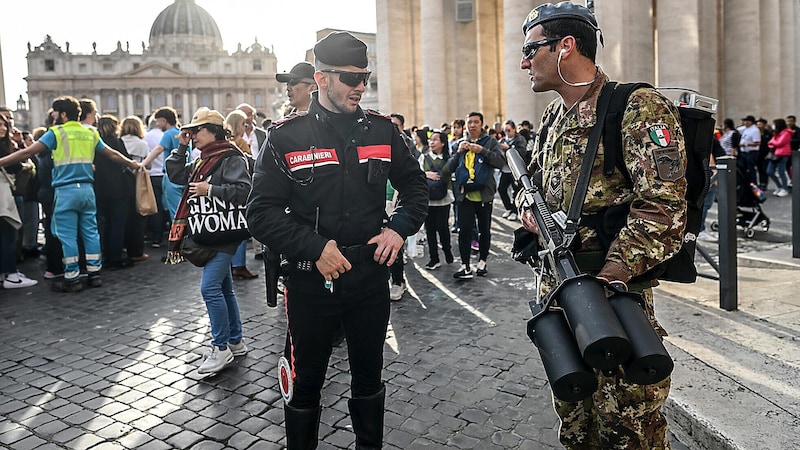 Ein Polizist blickt neidvoll auf die Anti-Drohnen-Kanone dieses Soldaten. Mithilfe der Waffe soll der Luftraum während Trauerfeierlichkeiten sicher bleiben. (Bild: EPA/ALESSANDRO DI MEO)