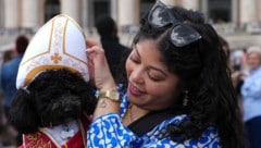 Diese Frau hat ihren Hund dem Anlass entsprechend eingekleidet. (Bild: AP/Emilio Morenatti)